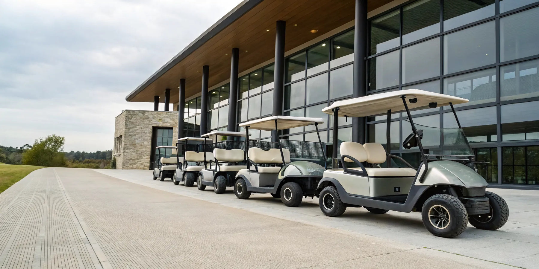 A row of the best 6 seater electric golf carts parked outside a clubhouse.