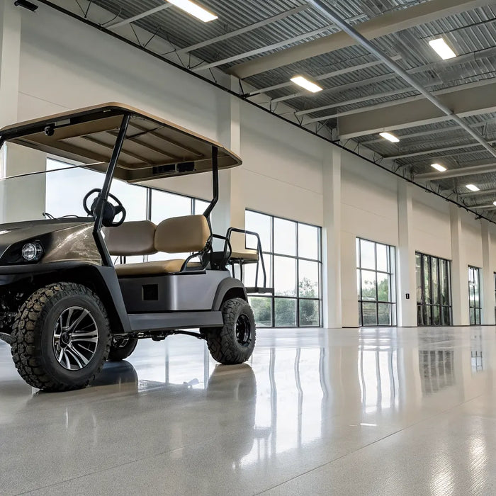 Lifted custom built golf cart with off-road tires for sale in a modern showroom.