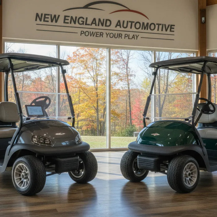 Gas and electric golf carts displayed side by side at a New England dealership with autumn foliage