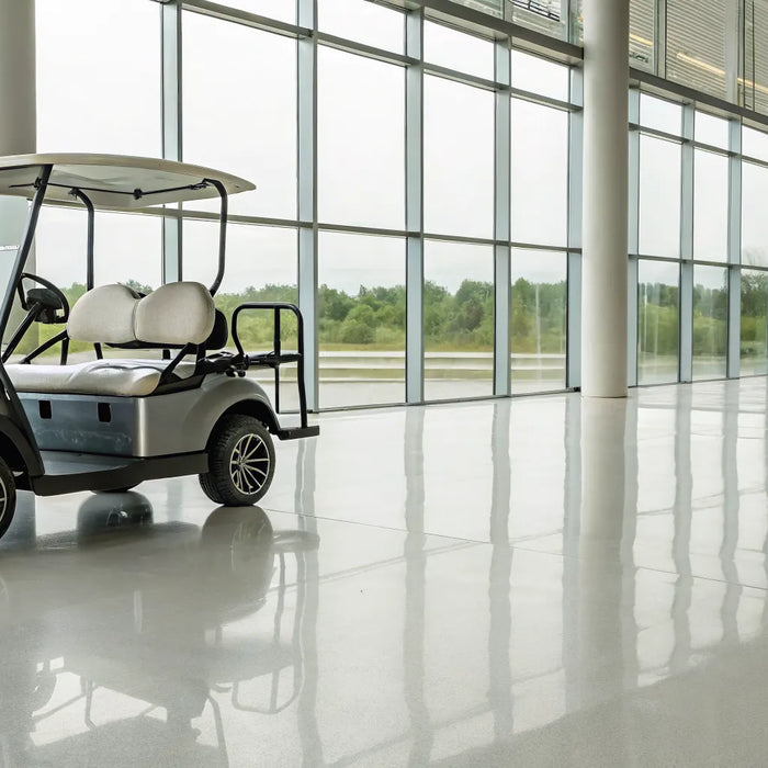 A new forward facing golf cart for sale on a showroom floor.