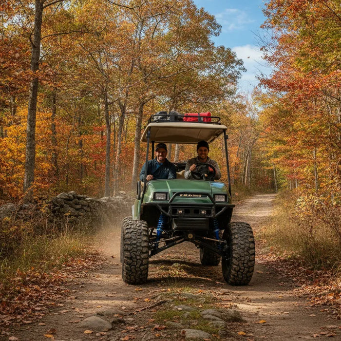 Lifted golf cart with oversized all-terrain tires driving on a rugged New England trail
