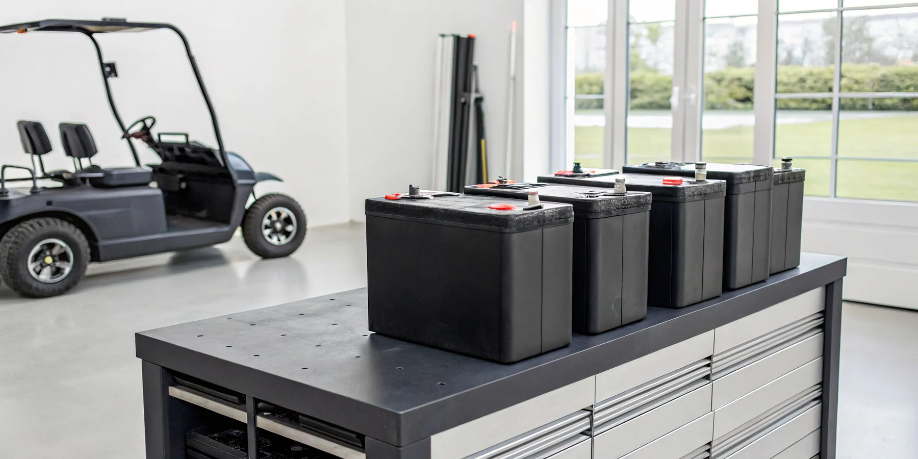 How much to replace golf cart batteries, shown on a workbench.