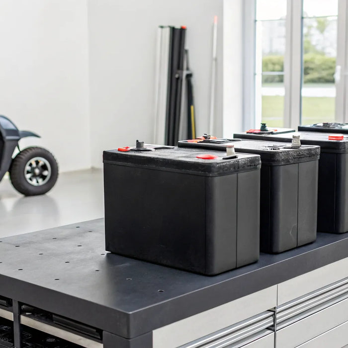 How much to replace golf cart batteries, shown on a workbench.