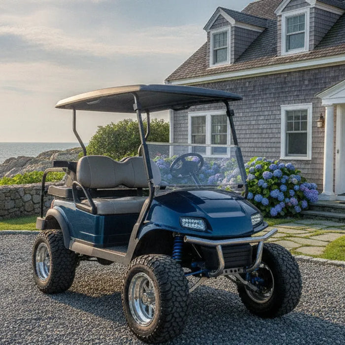 Lifted electric golf cart on a gravel drive in New England