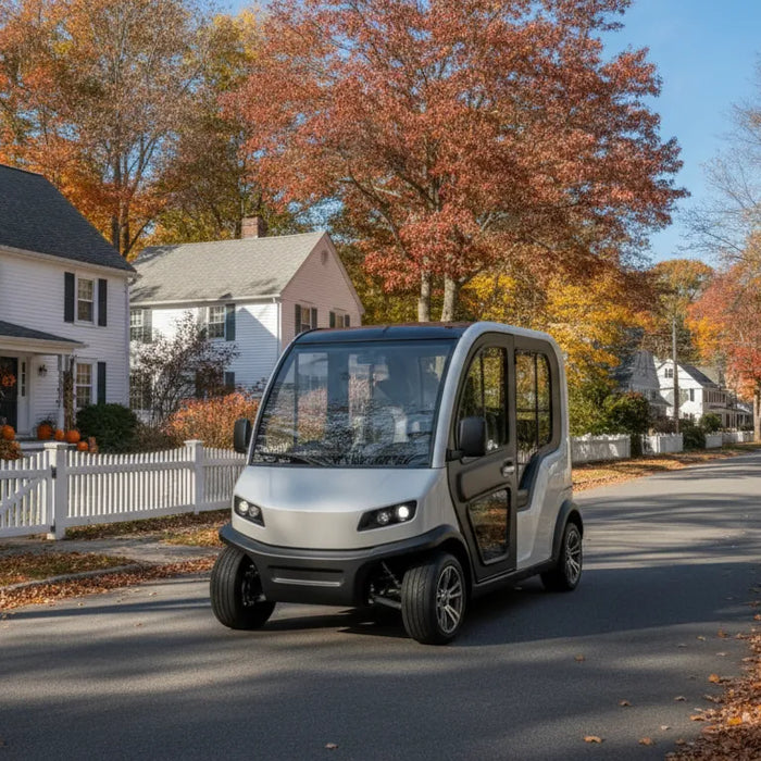 Electric low-speed neighborhood vehicle driving on a tree-lined street in a New England town