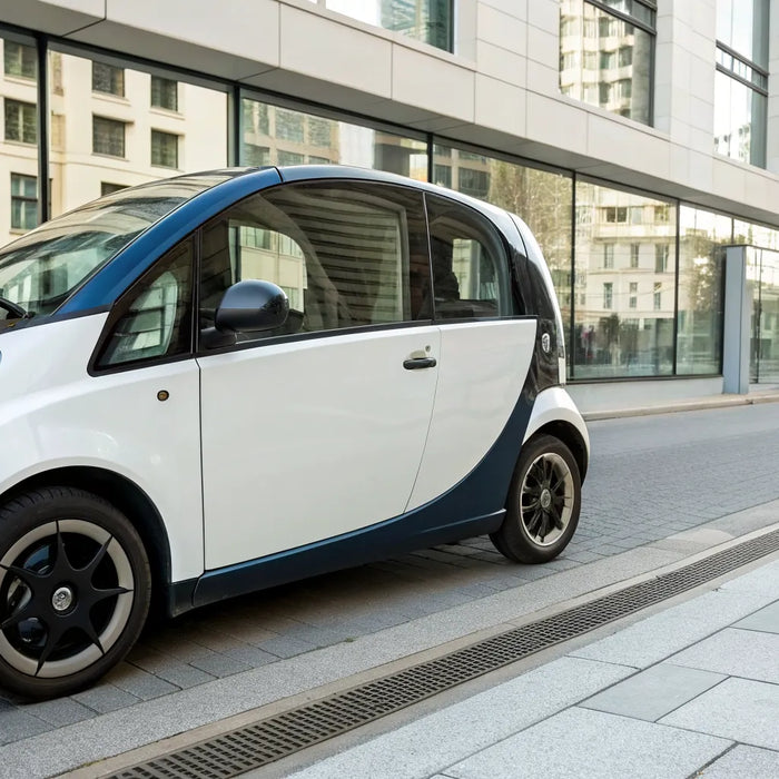 A compact street legal low speed vehicle parked on a city street.