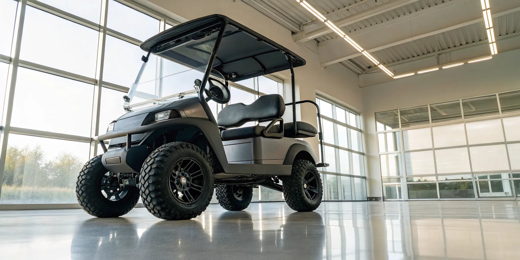 A modern lifted electric golf cart with large off-road tires and custom suspension.
