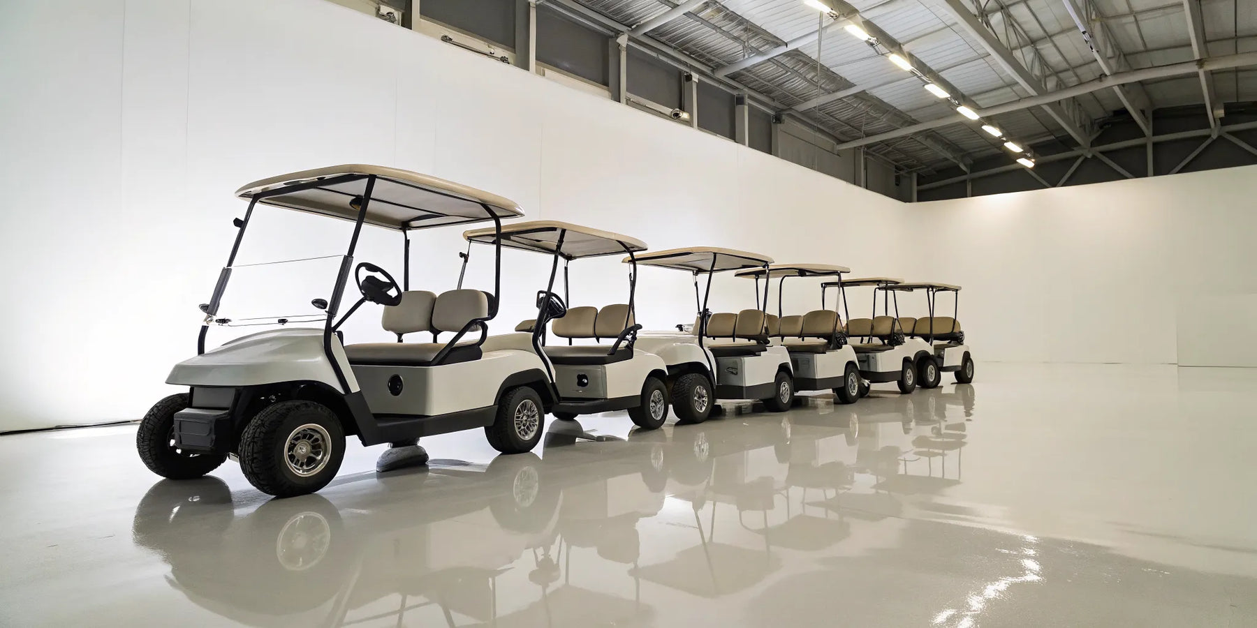 A row of modern 6-seater golf carts with seat belts.
