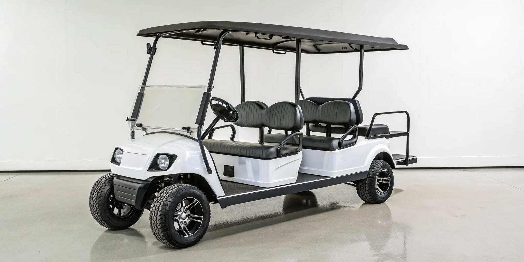 White used 6 seater gas golf cart for sale with black seats and off-road tires.