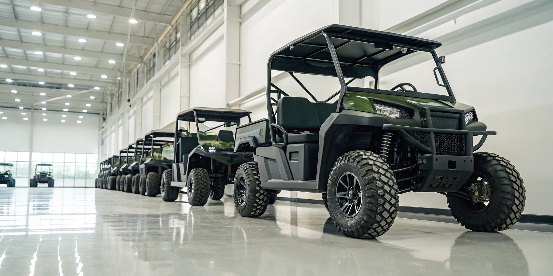 Monster lifted golf carts for sale with oversized tires in a showroom.