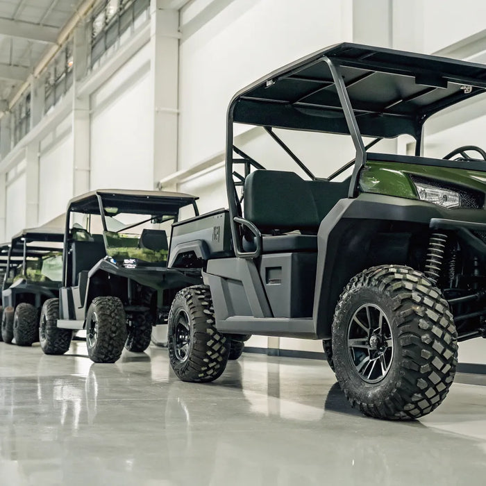 Monster lifted golf carts for sale with oversized tires in a showroom.